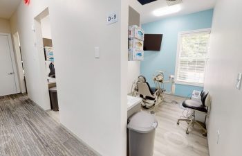 A treatment room with blue walls and a chair at Buford Family Dental
