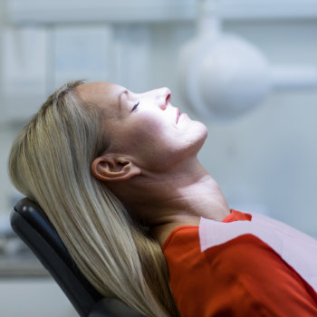 Woman patient under sedation in a dental chair