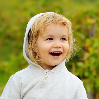 a happy toddler in a white hoodie