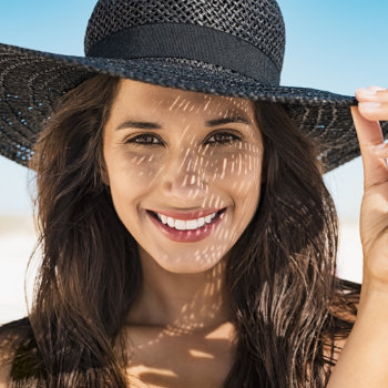 Smiling beautiful young woman wearing a summer hat