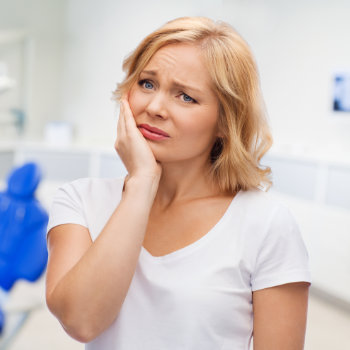 mature woman pressing her cheek due to dental pain